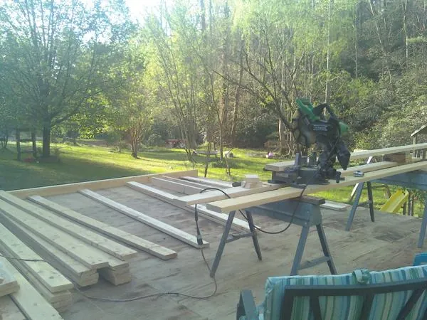 Miter saw and framing lumber on a deck under construction in Plains