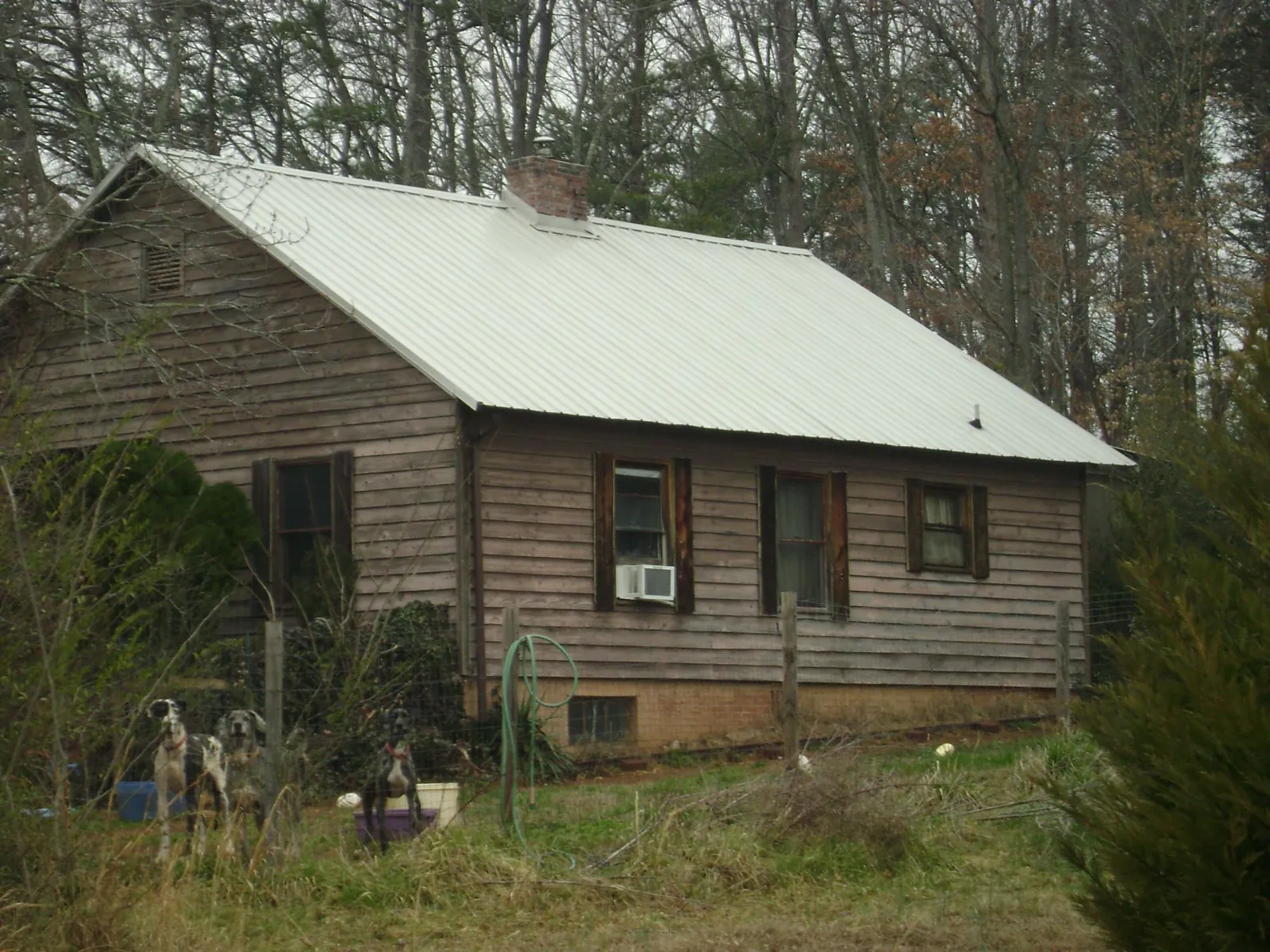 White metal roof on an old wood sided farmhouse, from a Asphalt Shingle Roof Repair job in Plains